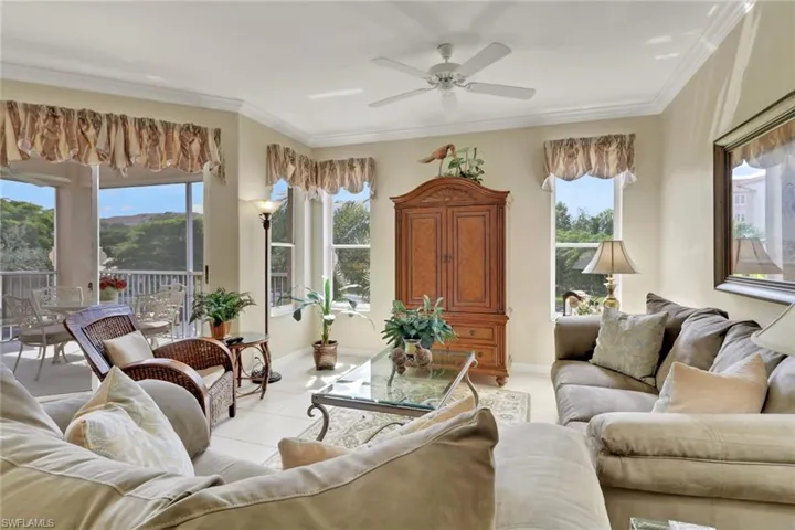 Living area with ornamental molding, ceiling fan, and tile patterned floors