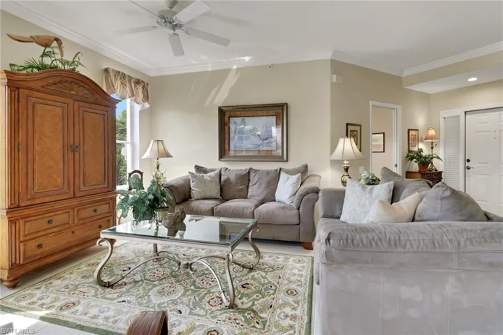 Living area with crown molding and ceiling fan