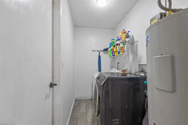 Laundry area with washing machine and clothes dryer and wood-type flooring
