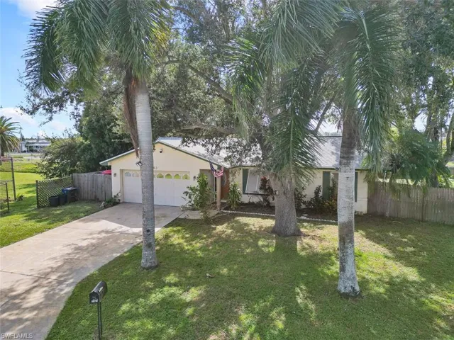Single story home featuring a garage and a front lawn