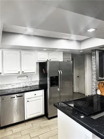 Kitchen featuring white cabinets, light wood-style floors, and stainless steel appliances