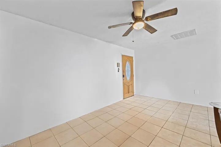 Tiled empty room featuring ceiling fan