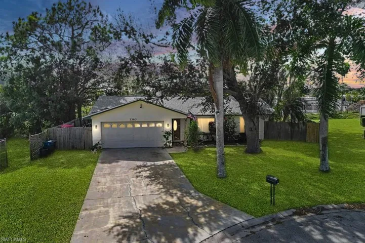 Ranch-style house with a yard and a garage