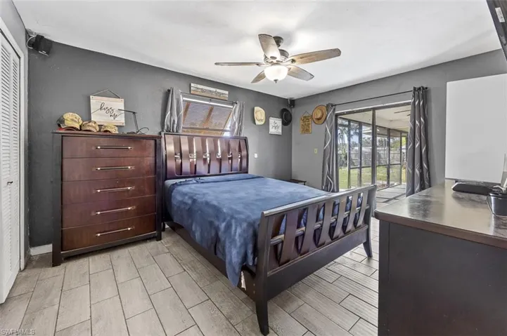 Bedroom featuring access to outside, light hardwood / wood-style floors, ceiling fan, and a closet