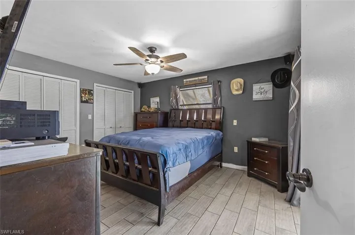 Bedroom featuring light wood-type flooring, multiple closets, and ceiling fan