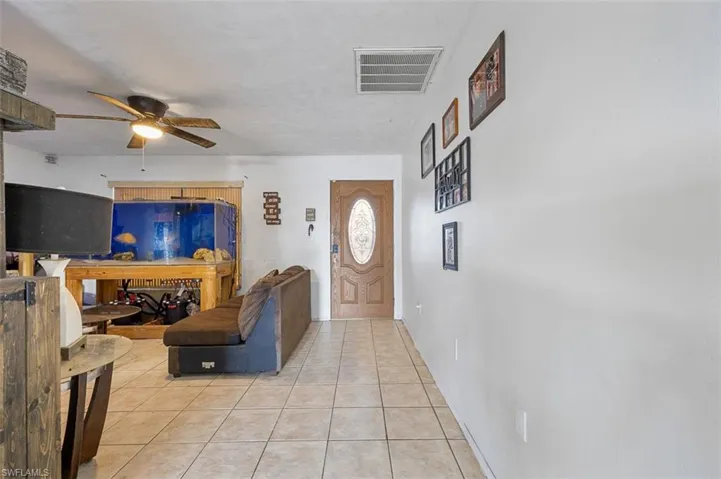 Foyer with ceiling fan and light tile patterned floors