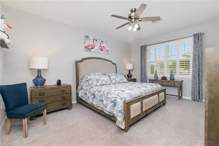 Carpeted bedroom featuring a ceiling fan and baseboards