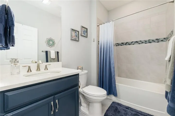 Full bathroom with shower / bath combination with curtain and vanity