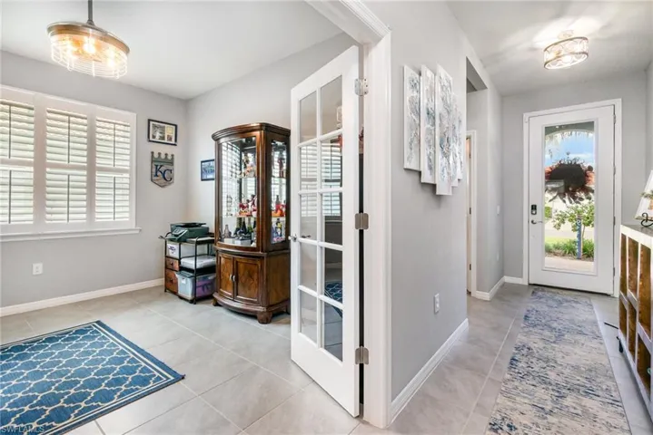Foyer entrance with light tile patterned floors and baseboards