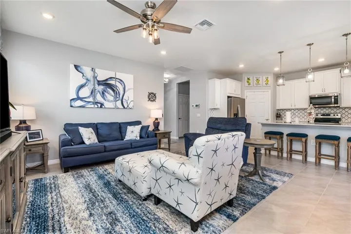Living room with recessed lighting, a ceiling fan, and light tile patterned floors