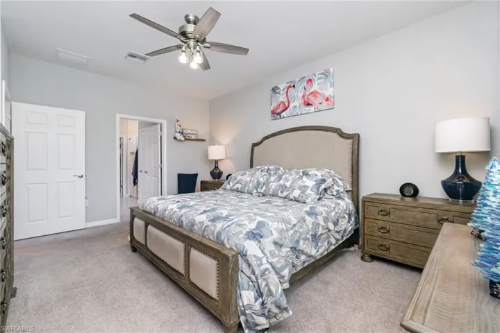 Bedroom with light carpet and a ceiling fan