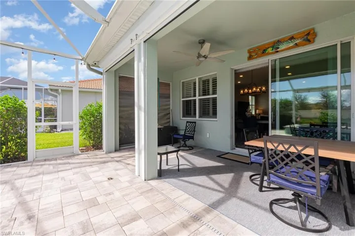 View of patio featuring a sunroom, glass enclosure, a ceiling fan, and outdoor dining area