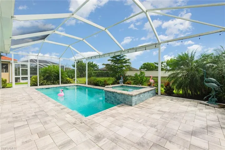 View of pool with glass enclosure, a sunroom, a pool with connected hot tub, and a patio