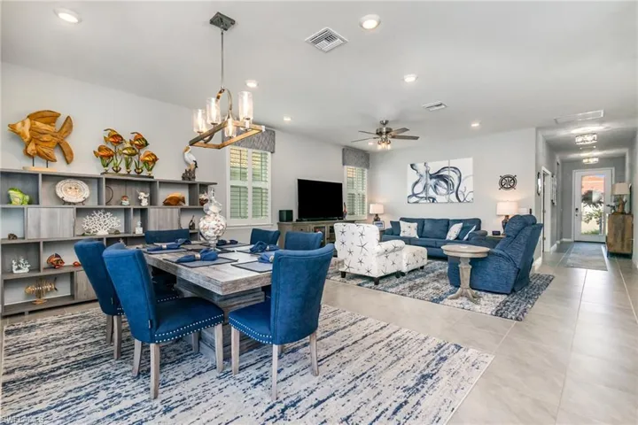 Dining room with a chandelier, recessed lighting, ceiling fan, and tile patterned flooring