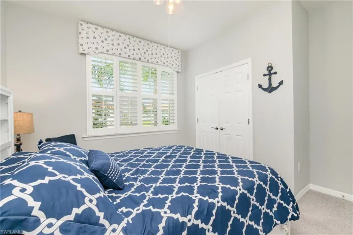 Carpeted bedroom featuring a closet and ceiling fan