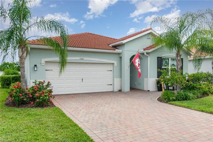 View of front of home with decorative driveway, an attached garage, stucco siding, a front yard, and a tile roof