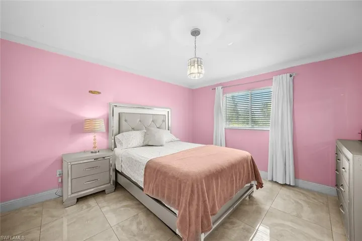 Bedroom with crown molding and baseboards