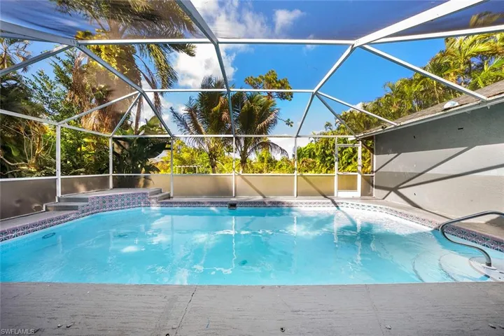 Outdoor pool featuring a sunroom and a lanai