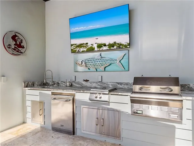 Outdoor kitchen with sink, fridge, smoker grill