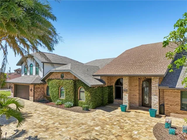 View of front of home with roof with shingles and brick siding