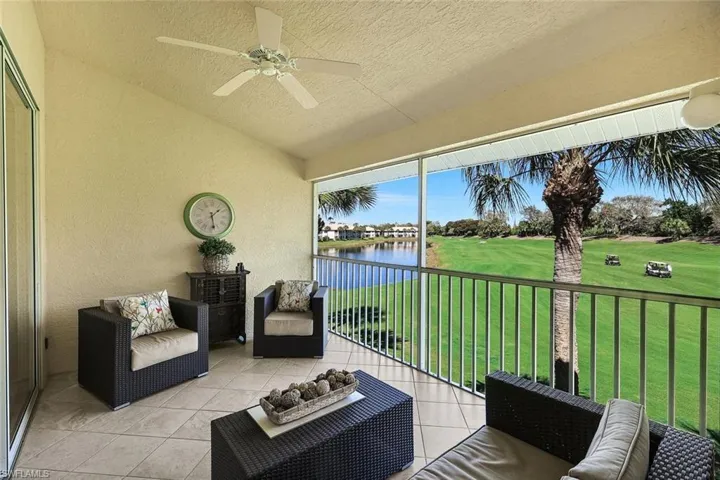 Sunroom with ceiling fan, lofted ceiling, a balcony, a water view, and view of golf course