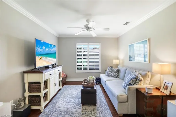 Living room with ornamental molding and ceiling fan