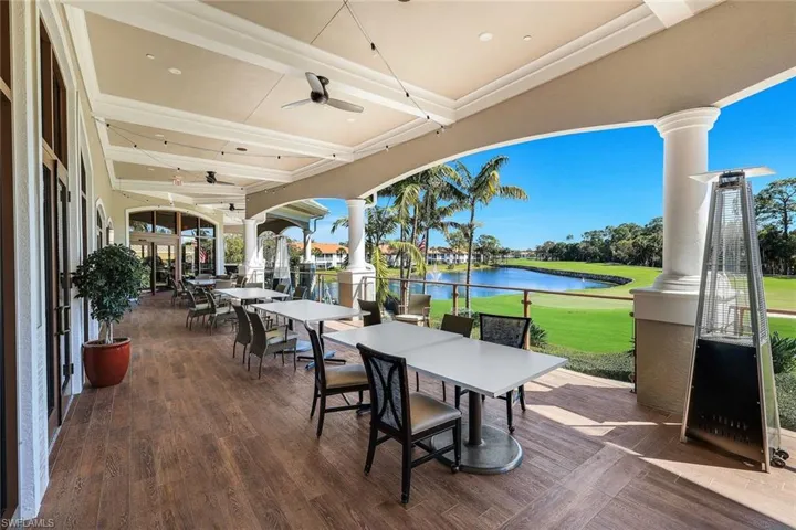 View of patio / terrace with a water view, outdoor dining area, a ceiling fan, and view of golf course