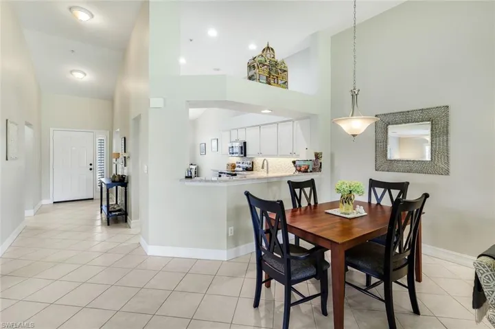Dining room with lofted ceiling and light tile patterned floors