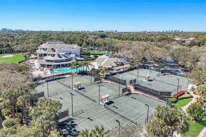 View of urban area featuring a pool and a tree filled landscape