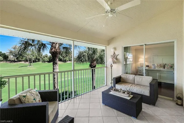 Sunroom / solarium featuring vaulted ceiling, ceiling fan, view of golf course, and an outdoor hangout area