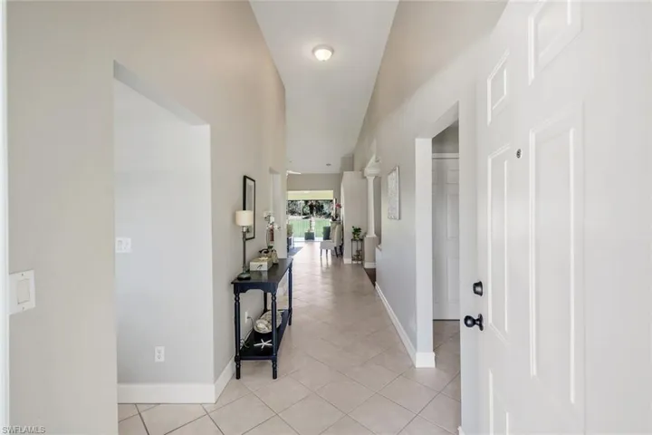 Hallway featuring baseboards and light tile patterned flooring