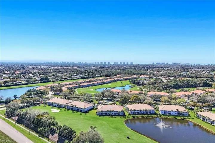 Aerial view of residential area with a nearby body of water and a golf club