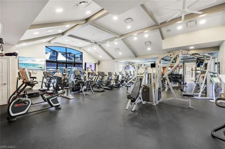 Exercise room featuring ceiling fan, a high ceiling, and recessed lighting