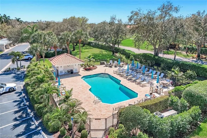 Community pool featuring a patio area and view of wooded area