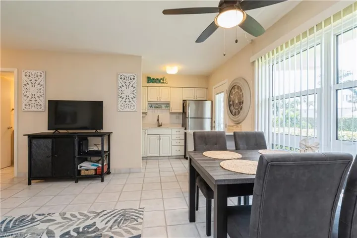 Tiled dining room with ceiling fan and sink