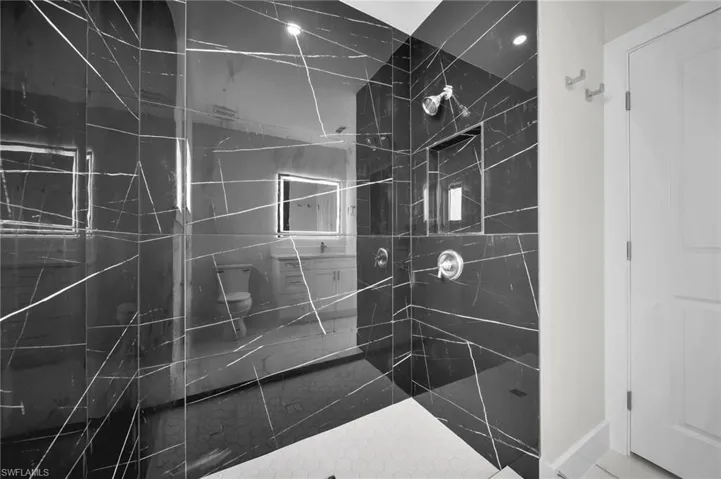Modern shower enclosure featuring striking black tiles with white veining