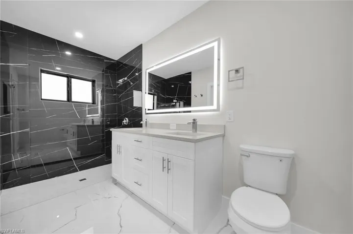 Modern bathroom featuring a dual vanity with white cabinetry and light-colored countertops