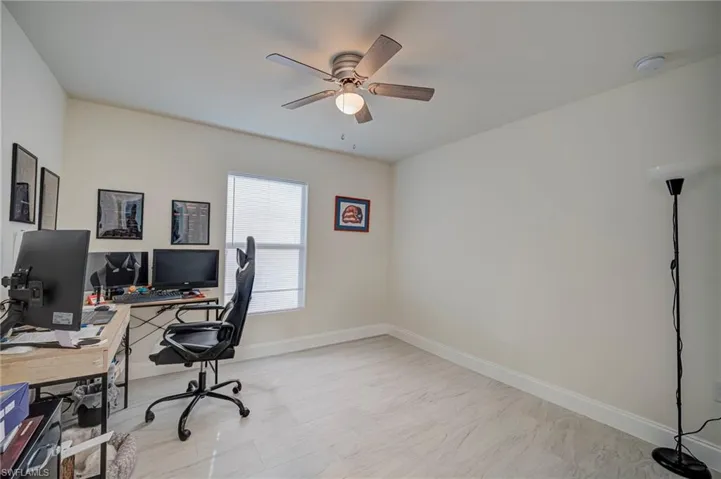 Home office with baseboards and ceiling fan