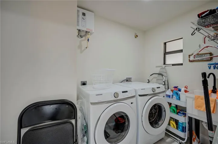 Laundry area with water heater and separate washer and dryer