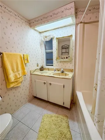 Full bathroom featuring vanity, toilet, shower / tub combo