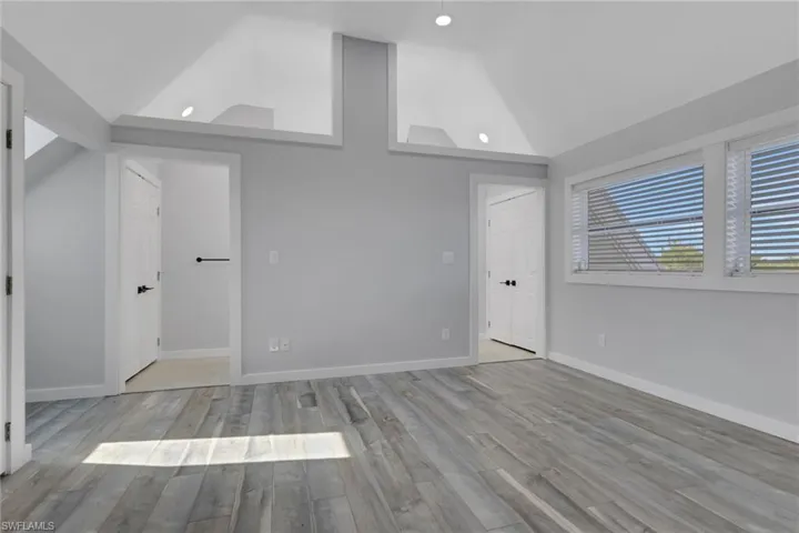 Unfurnished bedroom with light wood-style flooring, vaulted ceiling, and recessed lighting