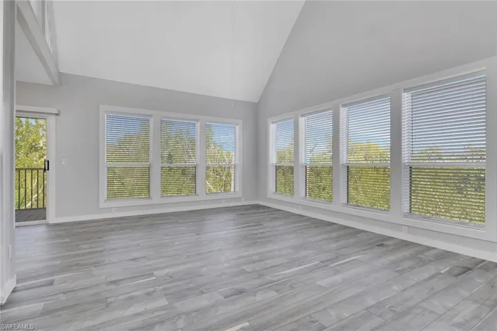 Unfurnished sunroom featuring vaulted ceiling