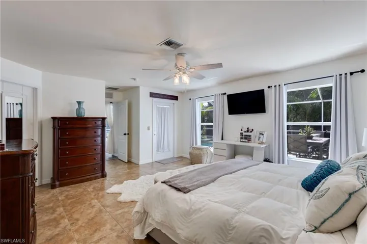 Tiled bedroom featuring a ceiling fan and baseboards