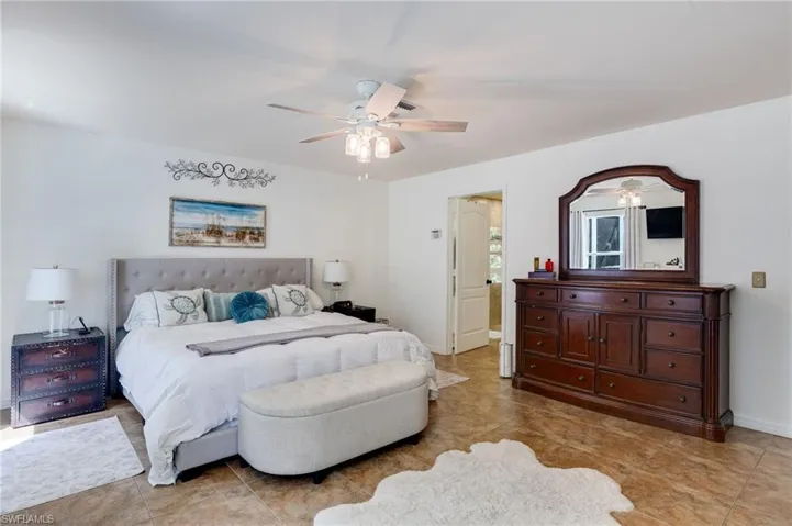 Bedroom with ceiling fan and light tile patterned floors