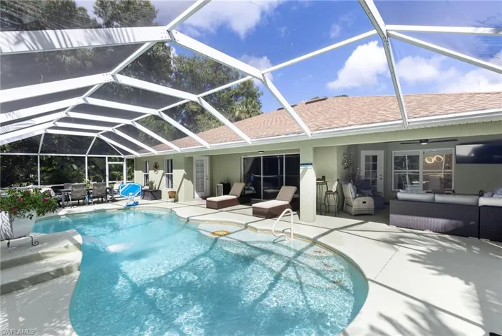 Back of house featuring an outdoor living space, a sunroom, a ceiling fan, a patio, and a lanai