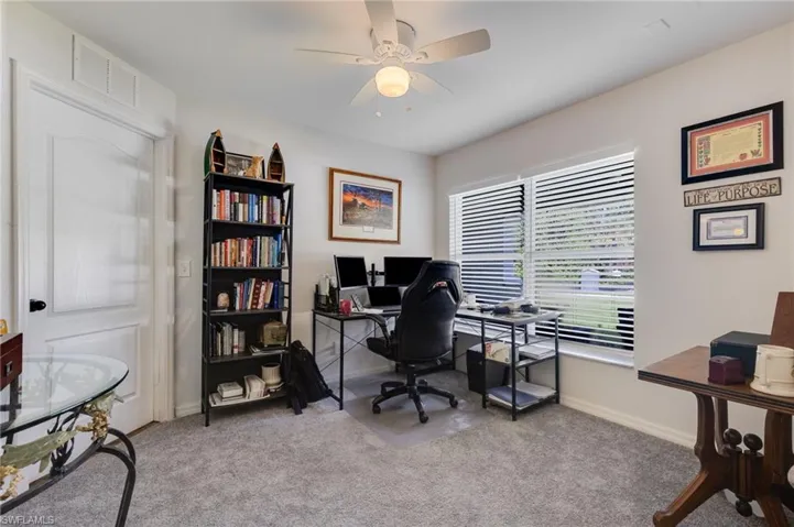 Office with light colored carpet and a ceiling fan
