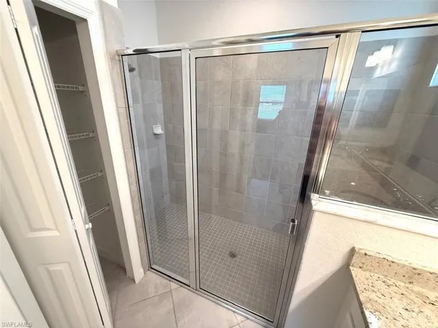Bathroom featuring a stall shower and light tile patterned floors