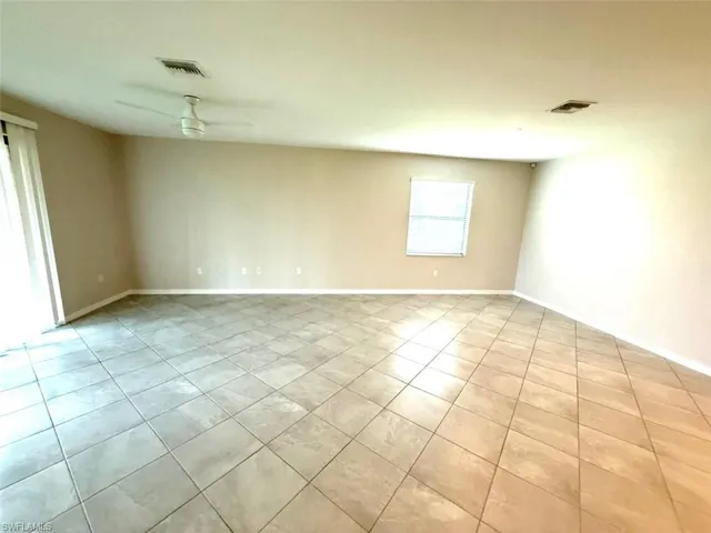 Unfurnished room with ceiling fan and light tile patterned flooring