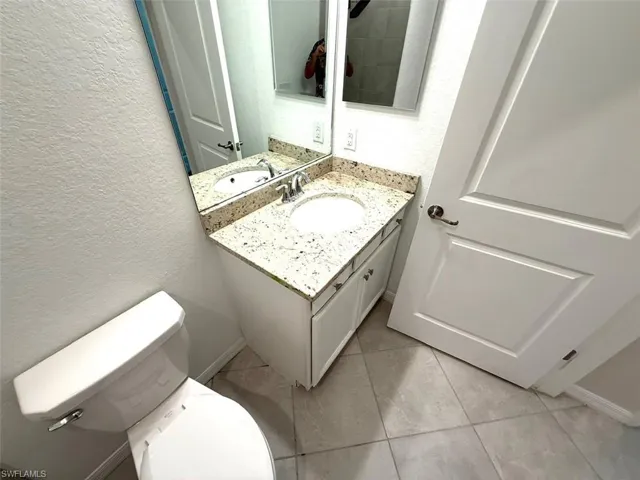 Bathroom featuring a textured wall and vanity