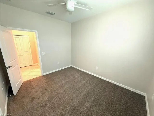 Spare room featuring carpet flooring and ceiling fan